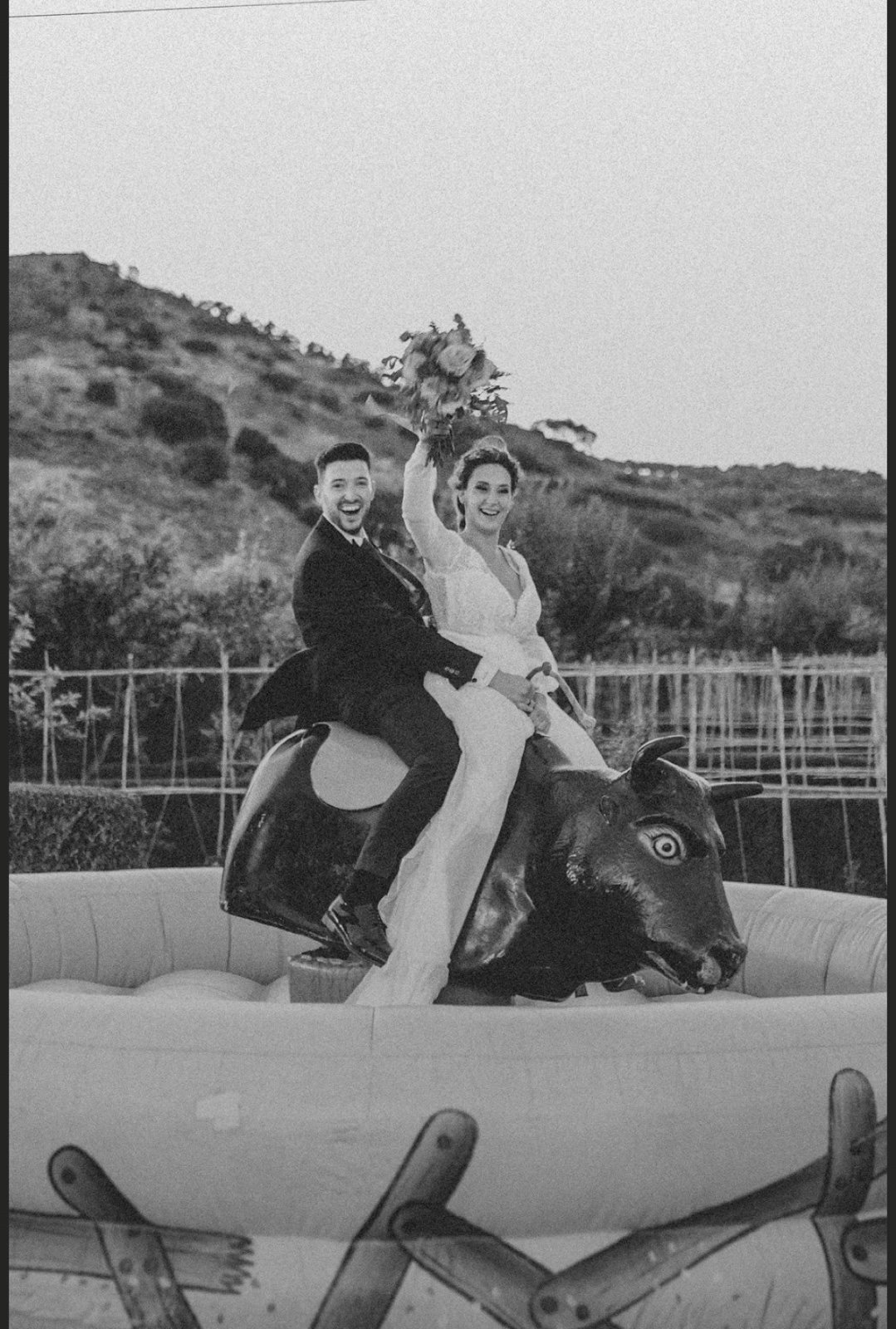 Novios subidos en toro mecanico.